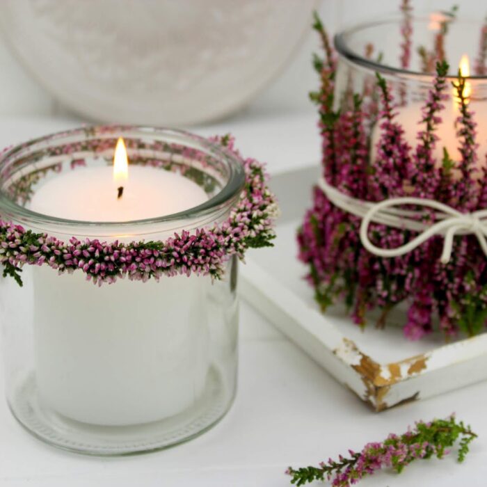 Windlichter und Blumenkränze mit Heidekraut an einem Windlicht