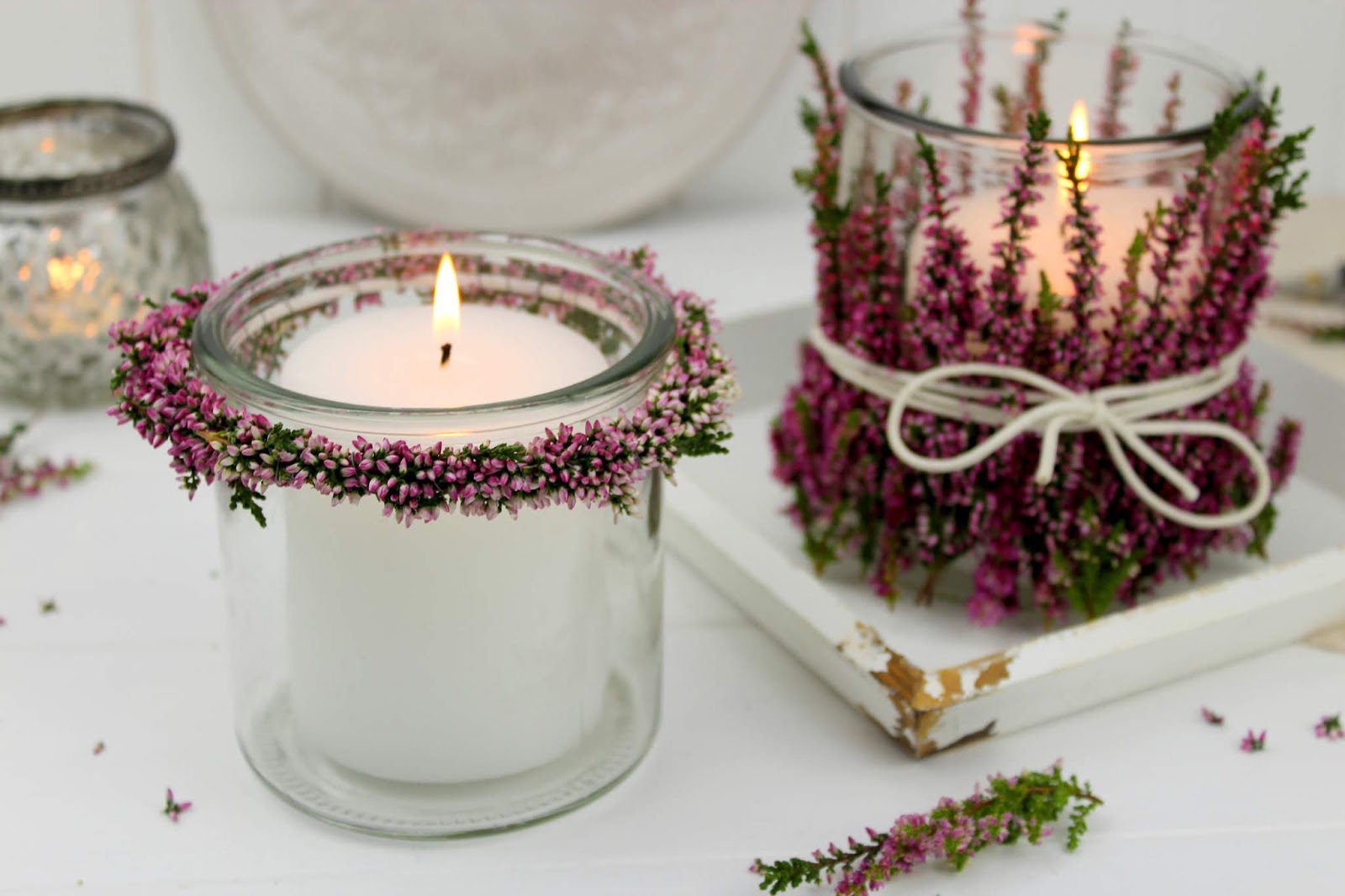 Windlichter und Blumenkränze mit Heidekraut an einem Windlicht