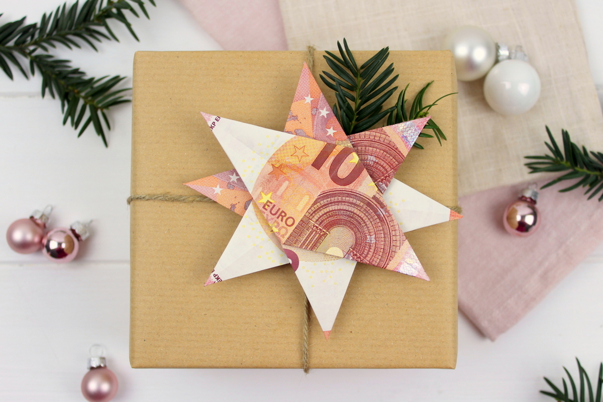 Origami Stern mit 10 Euro Scheinen auf einem Geschenk