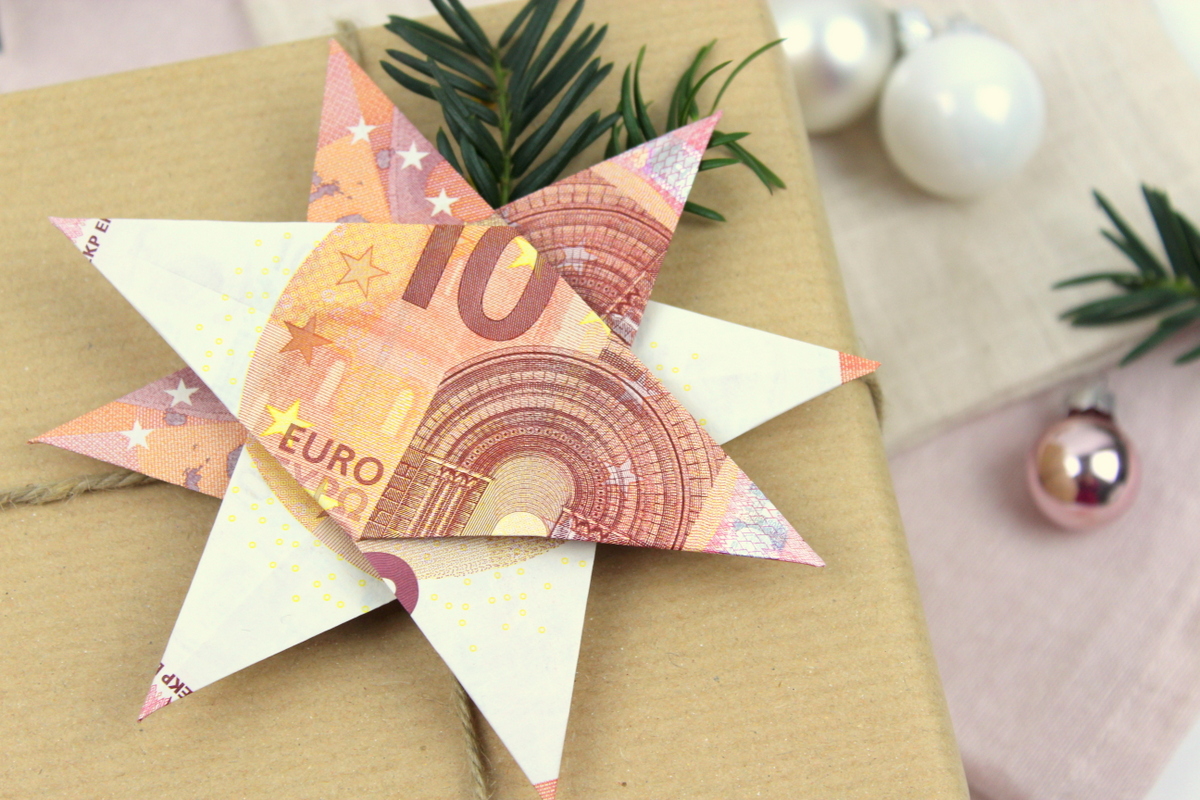 Origami Stern mit 10 Euro Scheinen auf einem Geschenk