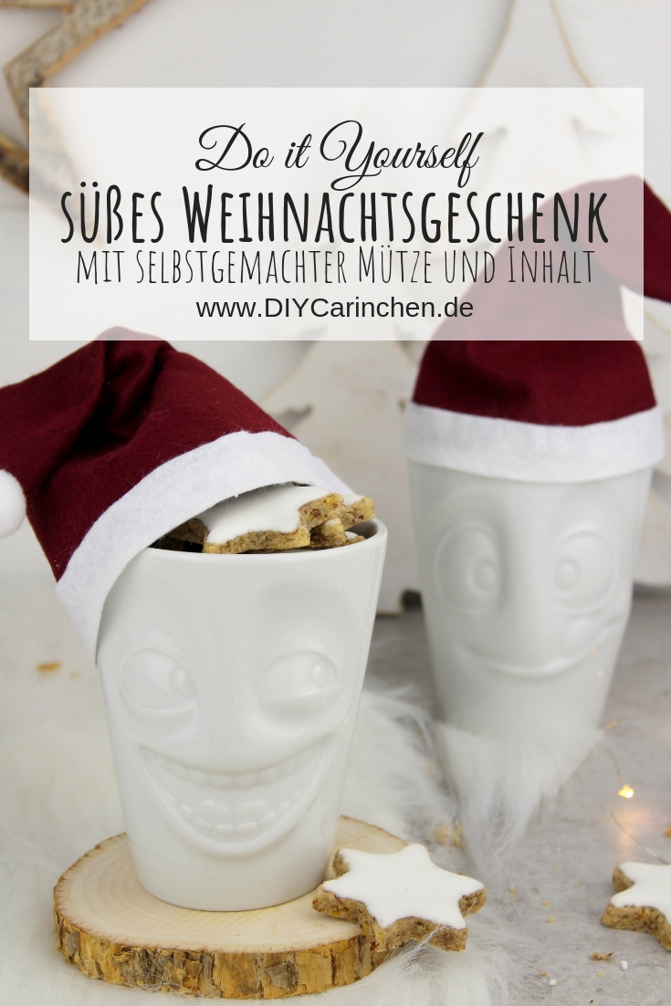 lustige Tassen mit Weihnachtsmannmützen gefüllt mit Zimtsternen