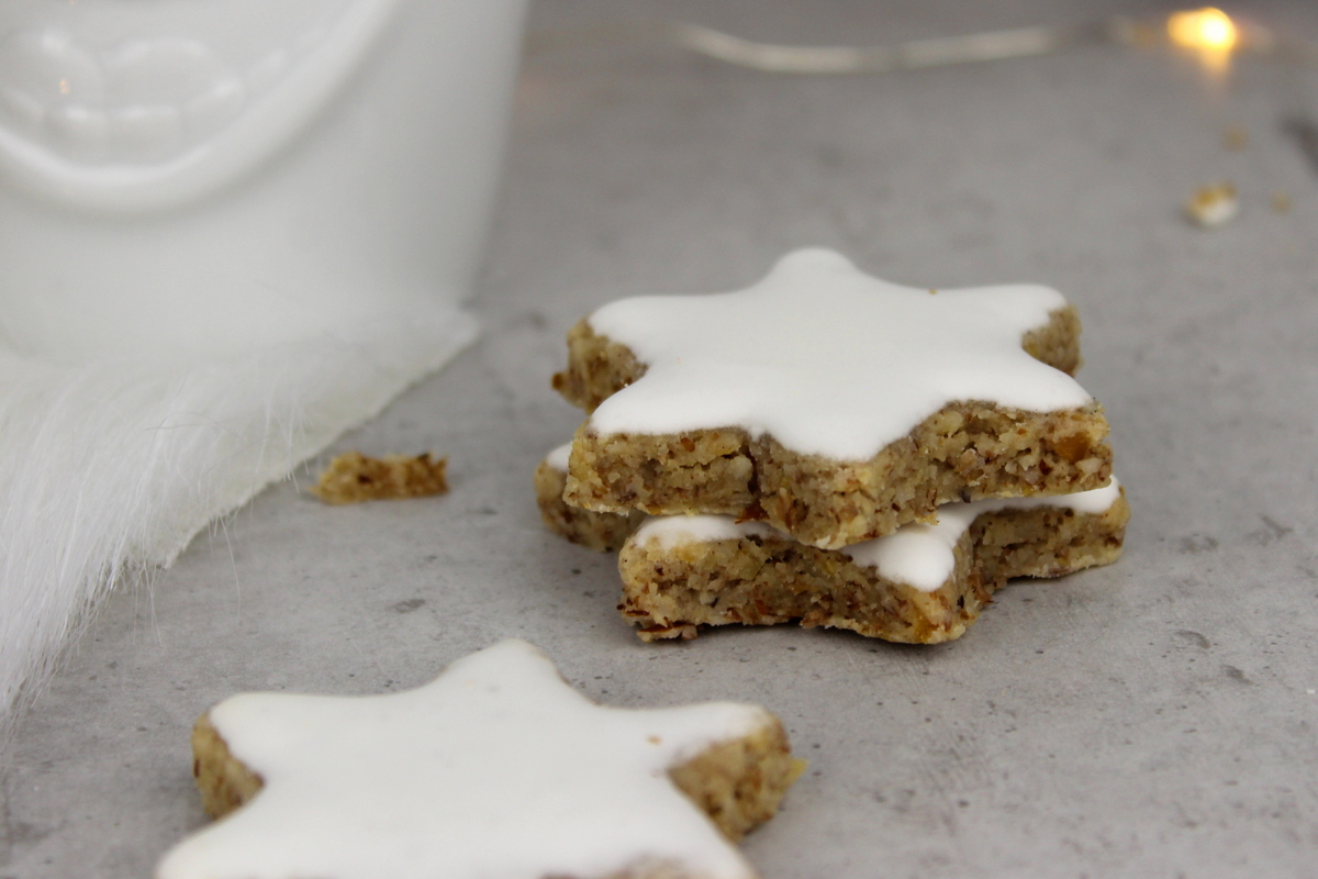lustige Tassen mit Weihnachtsmannmützen gefüllt mit Zimtsternen