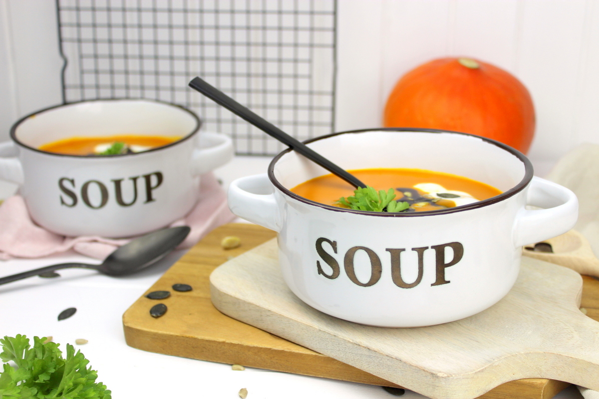 Kürbissuppe mit Hokkaido, Möhren und Kokosmilch serviert mit Petersilie, Kürbiskernen und Kürbisöl