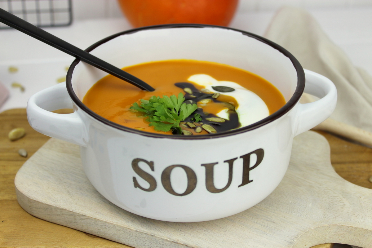 Kürbissuppe mit Hokkaido, Möhren und Kokosmilch serviert mit Petersilie, Kürbiskernen und Kürbisöl