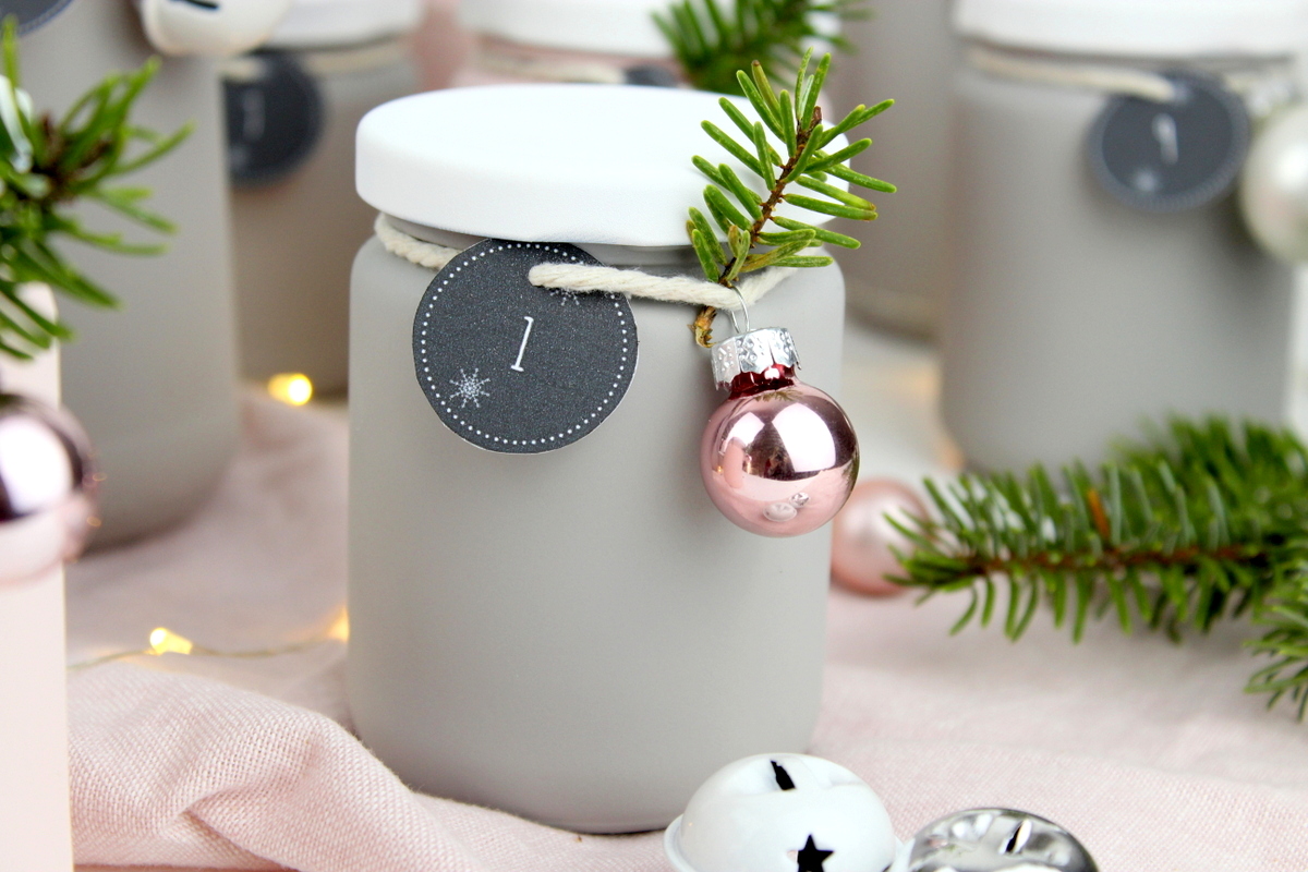 Upcycling Adventskalender aus alten angesprühten Gläsern mit Kreidefarbe in rosa und grau