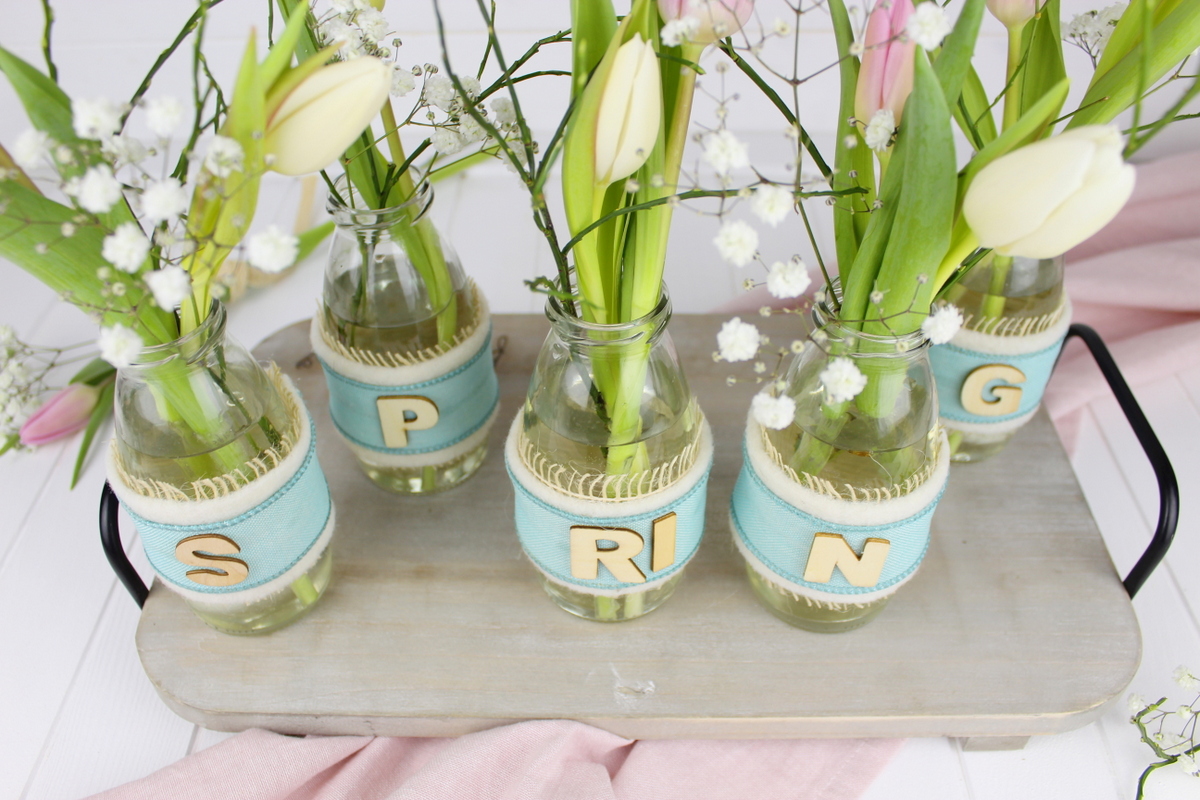 Upcycling Frühlingsdeko aus alten Flaschen mit Bändern
